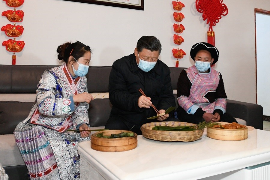 2021年2月3日下午，習(xí)近平在貴州畢節(jié)市黔西縣新仁苗族鄉(xiāng)化屋村苗族村民趙玉學(xué)家，同一家人邊聊家常邊制作當(dāng)?shù)貍鹘y(tǒng)節(jié)日食品黃粑。新華社記者 李學(xué)仁 攝