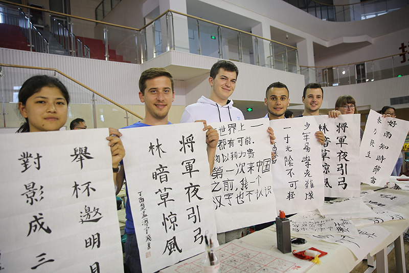 2017年6月5日，來自青島大學(xué)和中國(guó)石油大學(xué)（華東）的外國(guó)留學(xué)生在展示剛剛現(xiàn)場(chǎng)完成的書法作品。